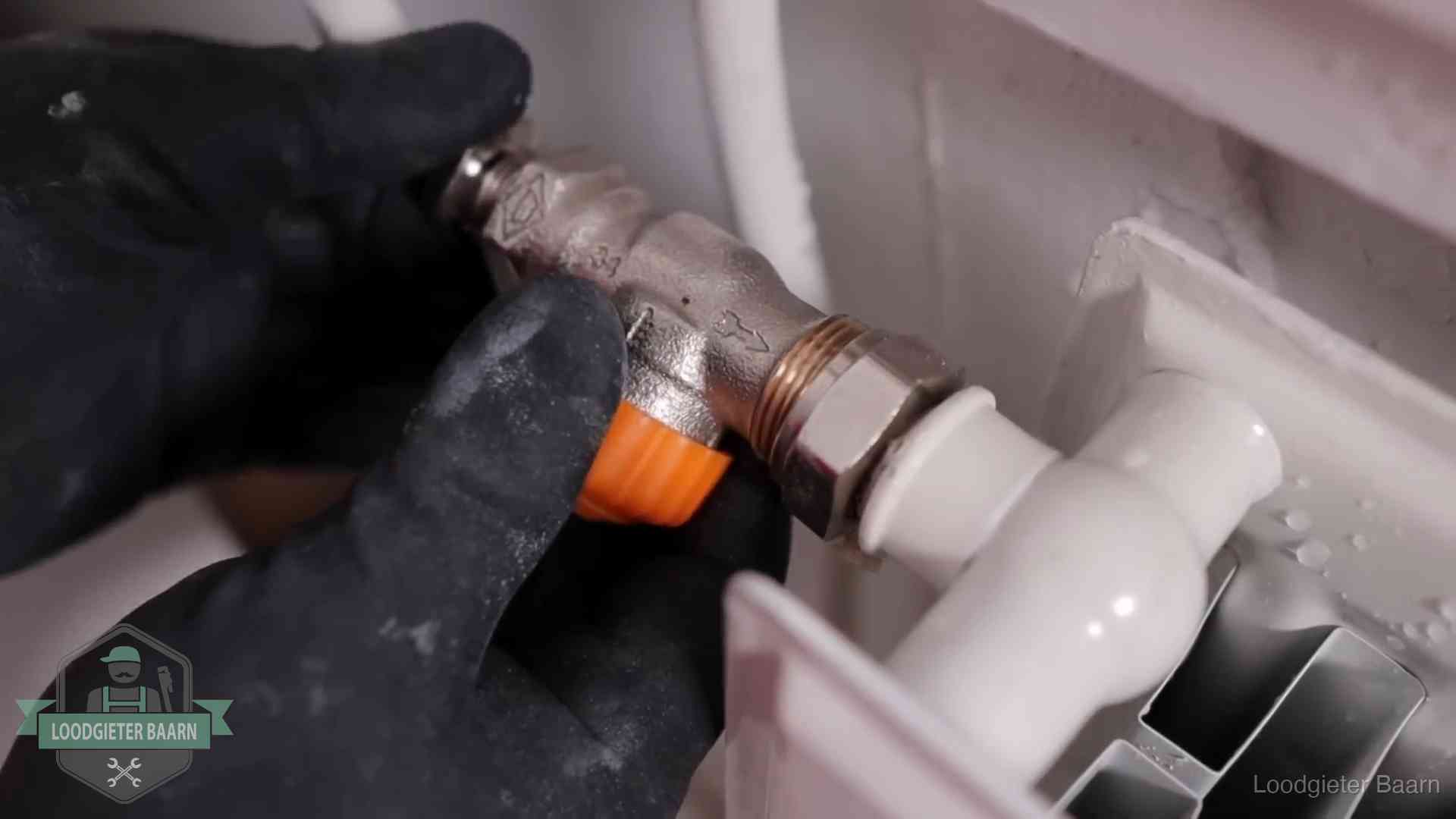 Thermostaatkraan wordt gemonteerd op een radiator in Baarn voor het stookseizoen