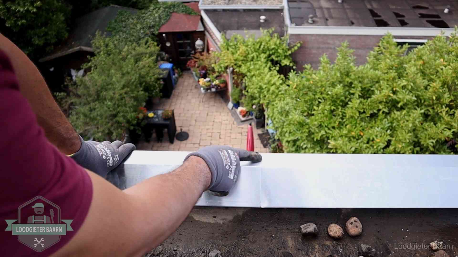 Daklekkage geregeld in Baarn Vakman plaatst een daktrim op de dakrand van een woning in Baarn