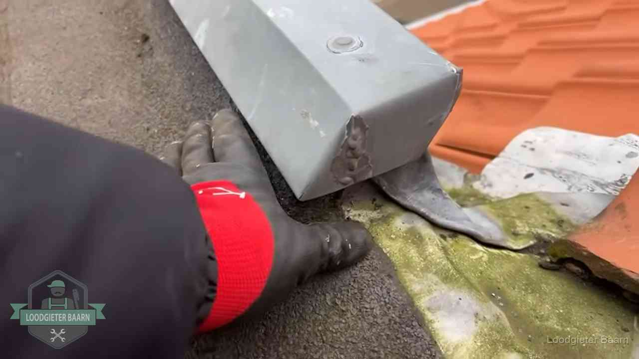 Hemelwaterafvoer en dakgoot controleren in Baarn Controle van een zinken hemelwaterafvoer met loodslab bij dakpannen in Baarn
