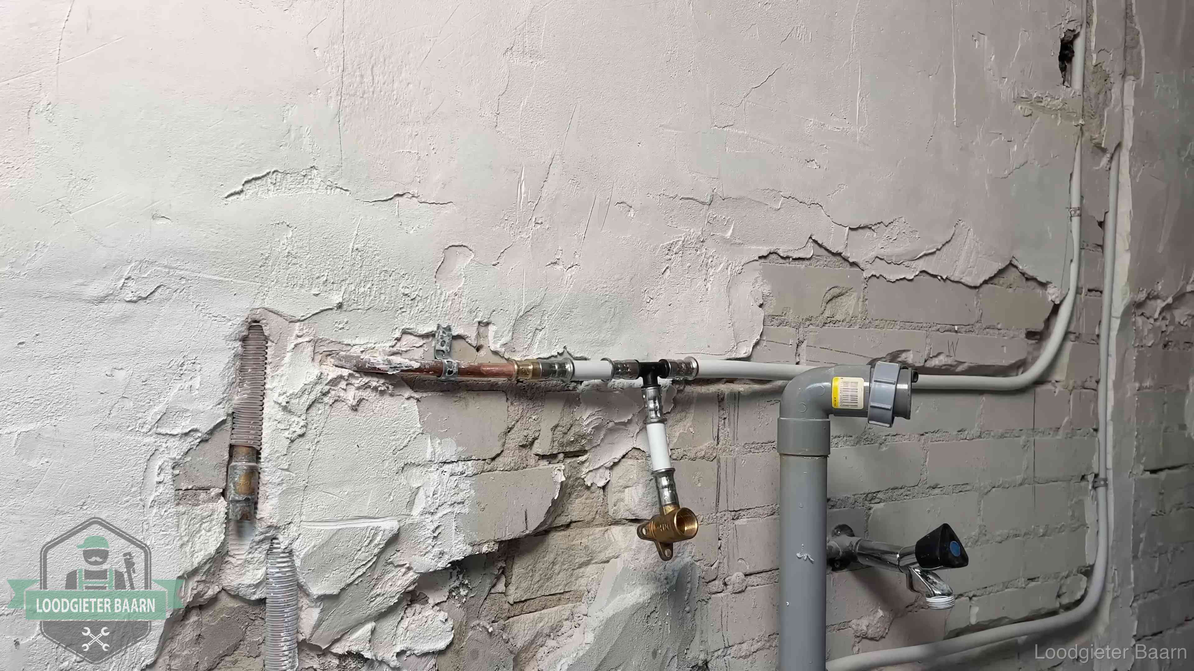 Nieuw leidingwerk naast een oud verroest leidingrestant in een woning in Baarn