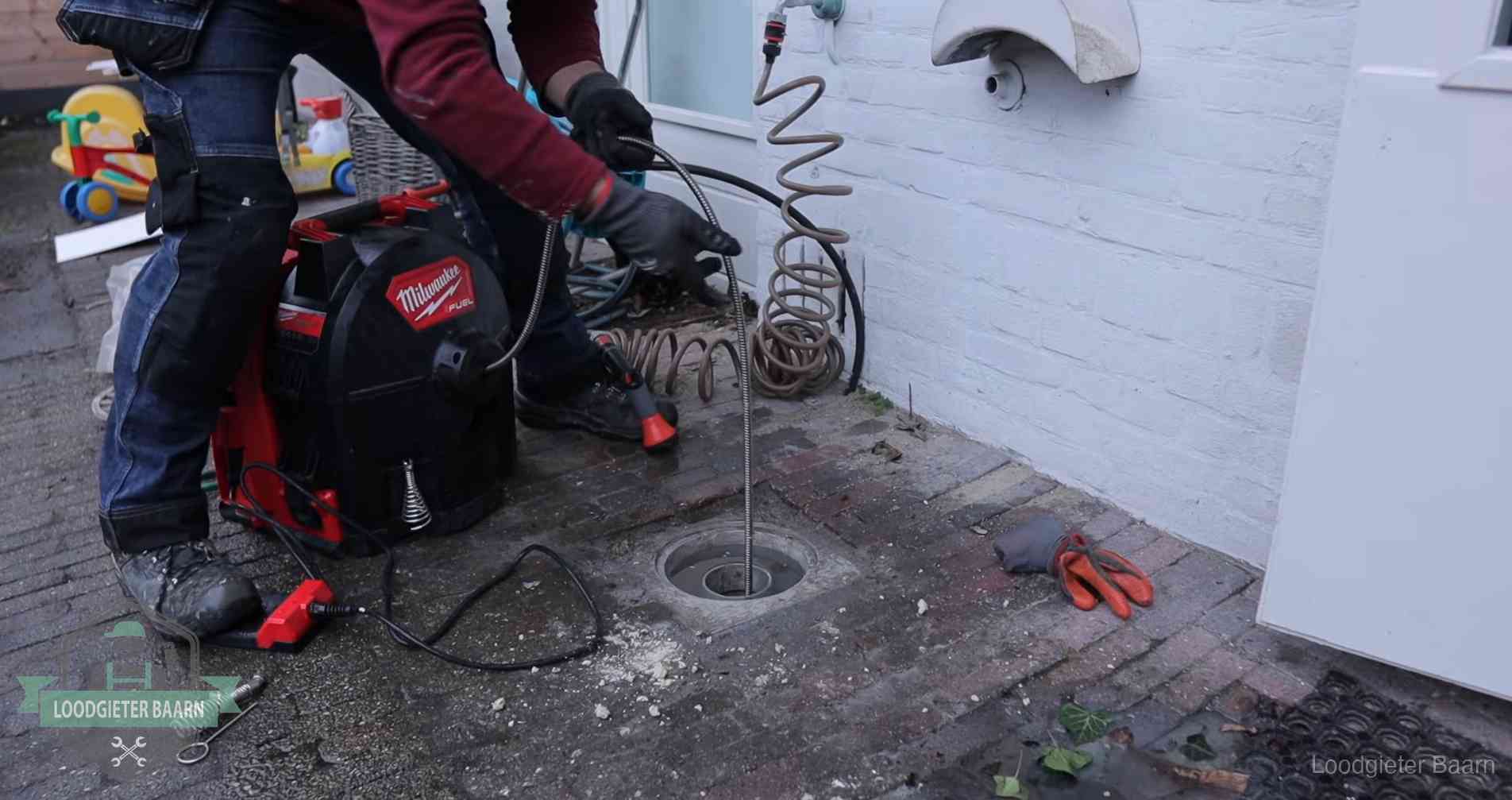 Erfgrens en gemeenteriool in Baarn Ontstoppingsputje in de bestrating naast de gevel van een woning in Baarn
