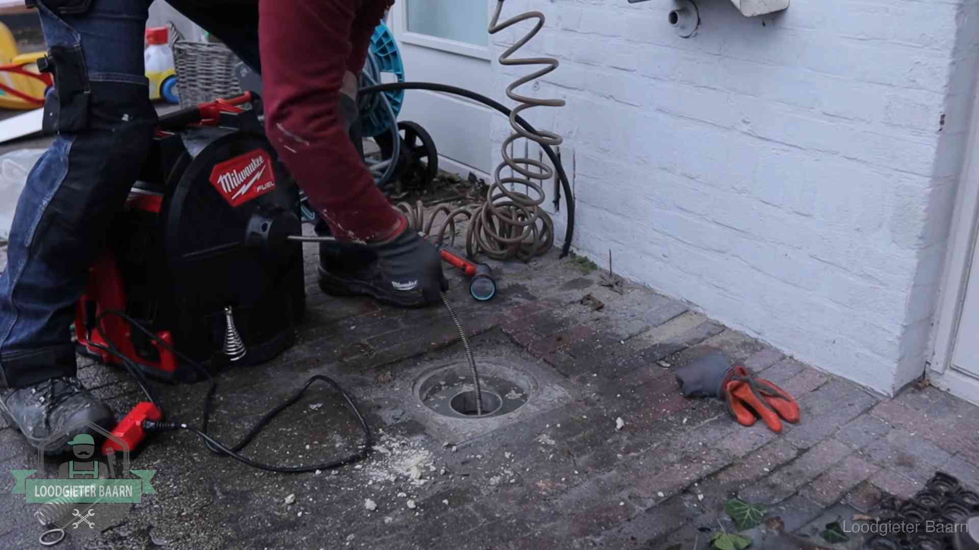 Prijs van een rioolontstopping in Baarn Spiraalmachine bij een ontstoppingsputje in de bestrating in Baarn