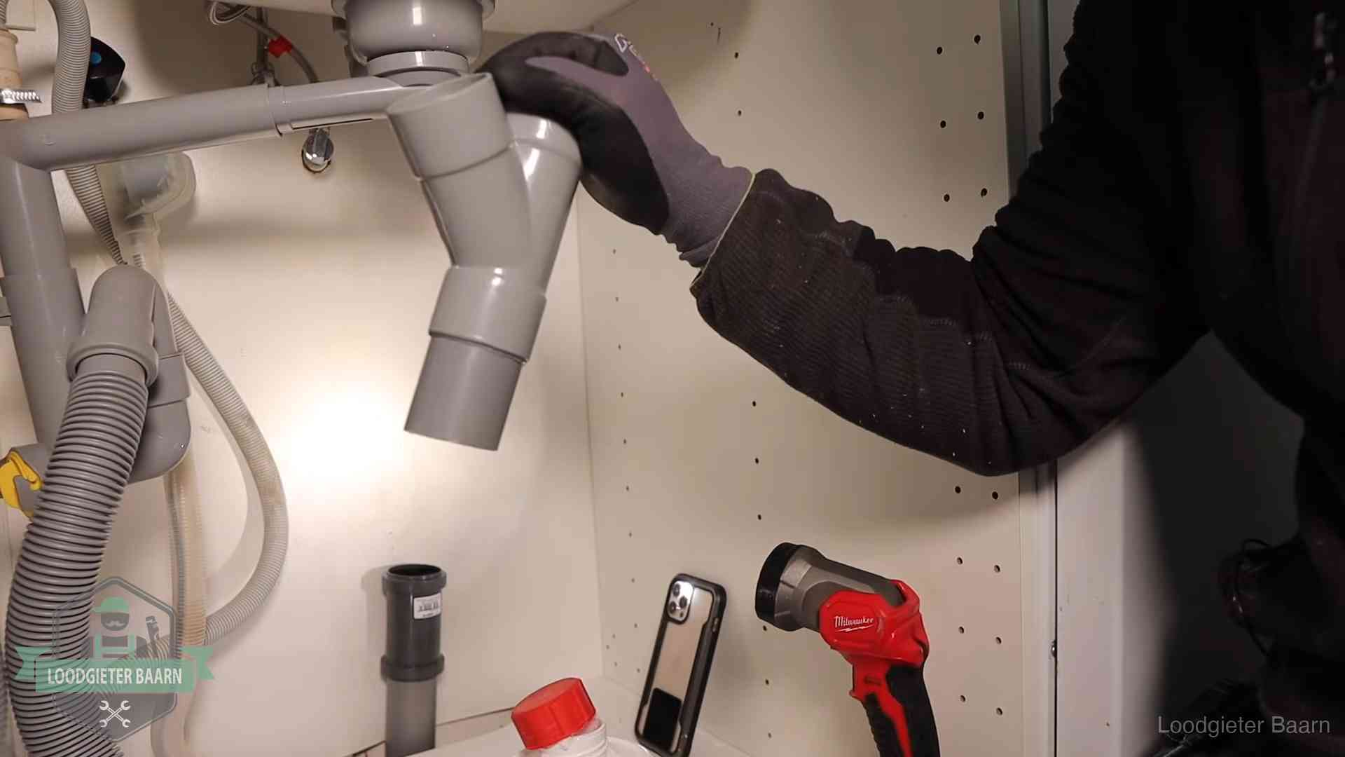 Rioollucht in huis verhelpen in Baarn Loodgieter demonteert het sifon- en afvoerwerk onder een gootsteen in Baarn bij stankklachten