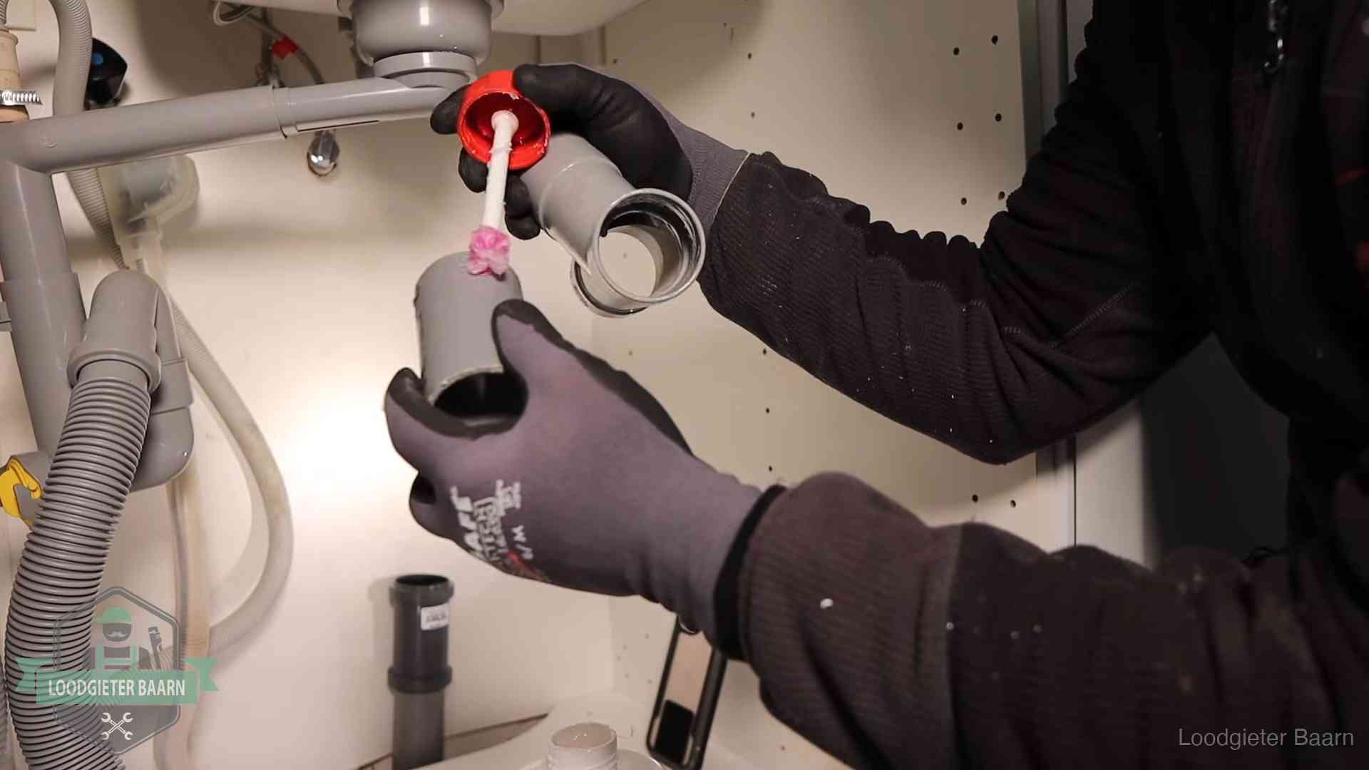 Oorzaak van een verstopte afvoer in Baarn Loodgieter demonteert en reinigt de sifon onder een keukenkast in Baarn