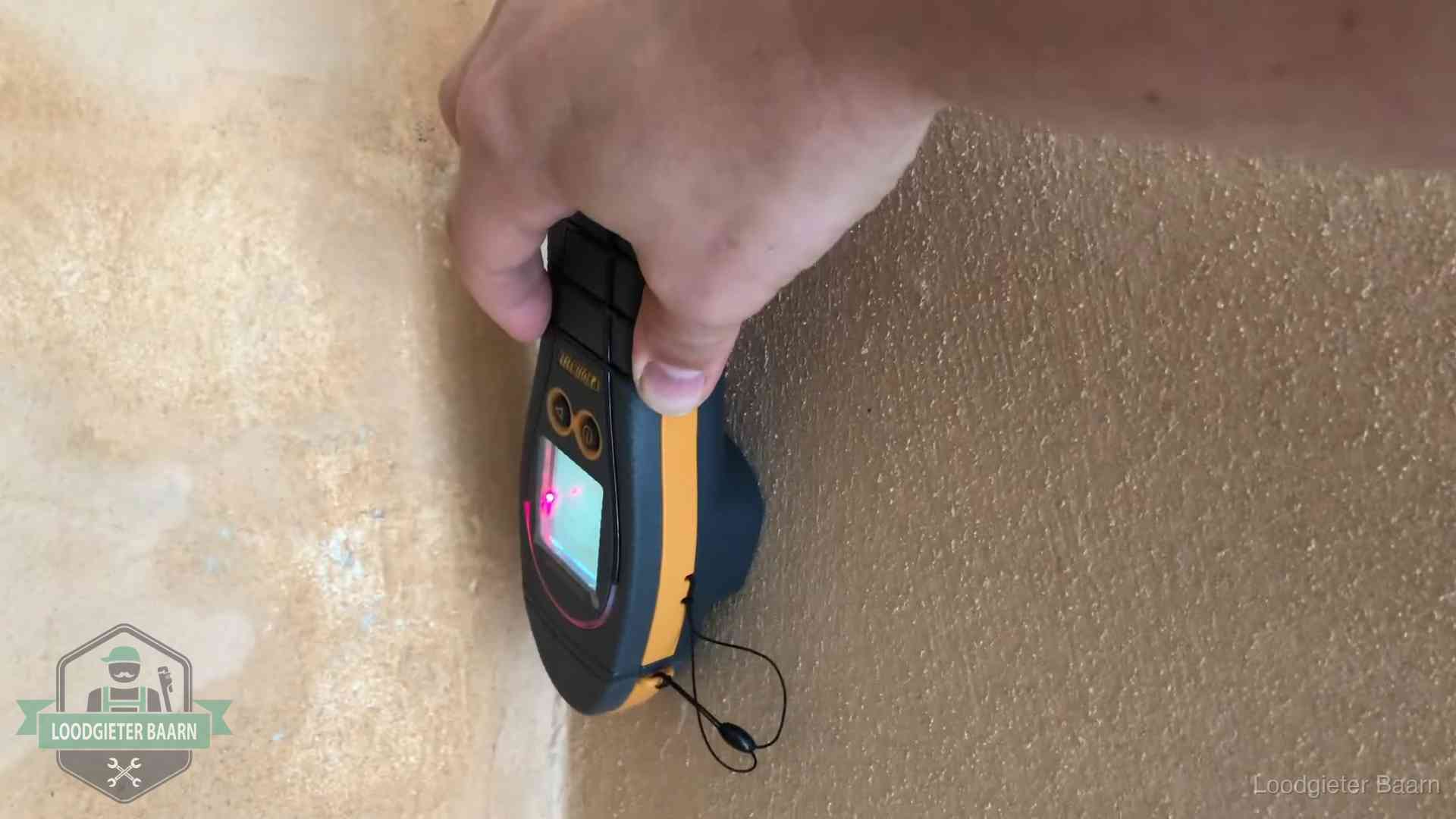 Daklekkage opsporen zonder hakwerk in Baarn Vochtmeter tegen een muur met vochtplekken tijdens het opsporen van een daklekkage in Baarn
