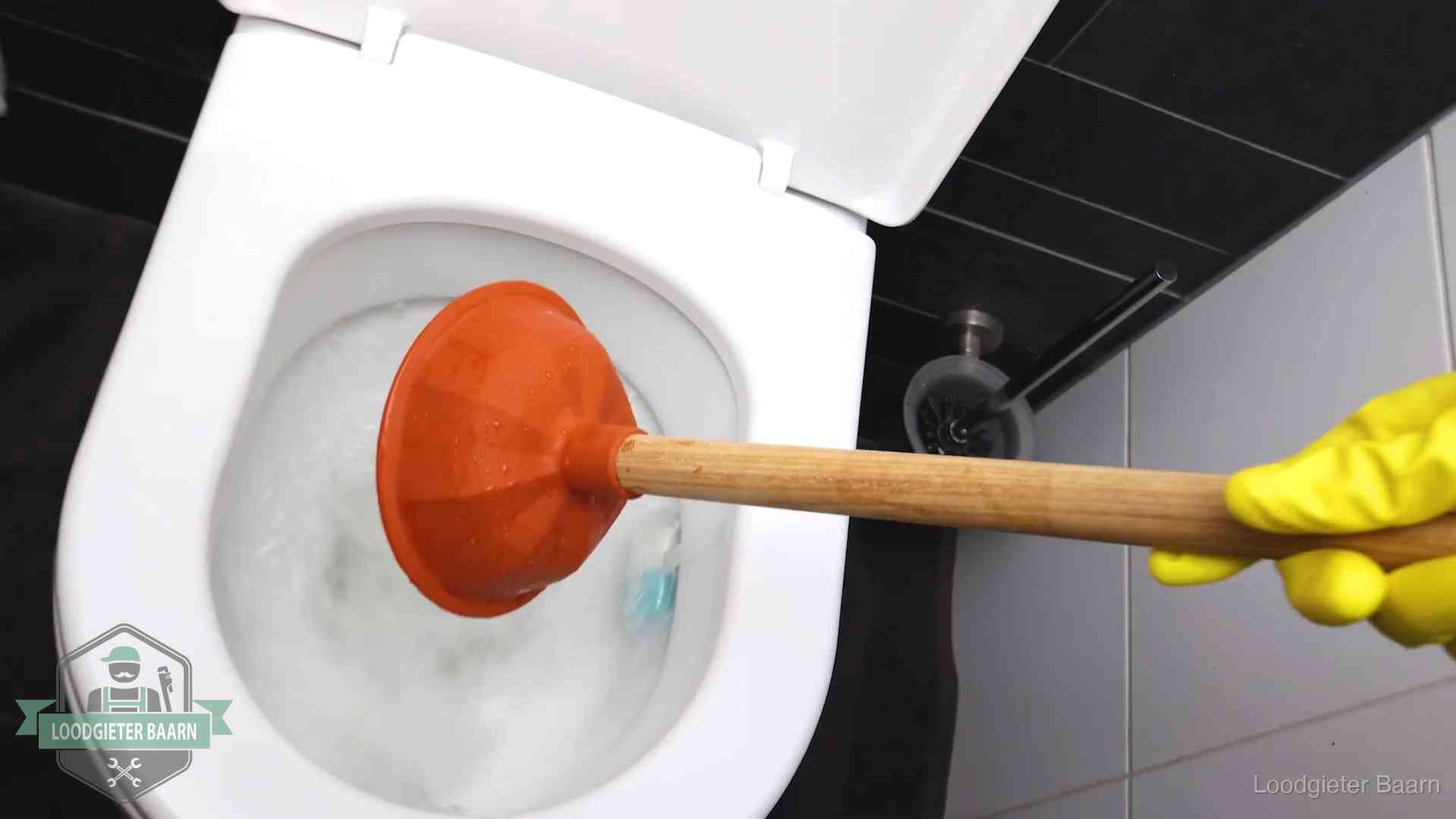 Wc ontstoppen met de plopper in Baarn Plopper wordt in de wc-pot gedrukt bij het ontstoppen van een toilet in Baarn